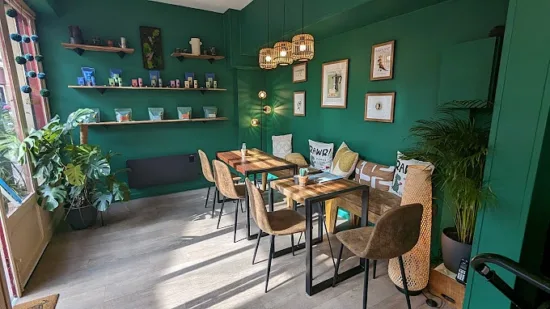 The inside of RAWr has emerald green walls and wood finishes. Open shelves hold coffee bags.