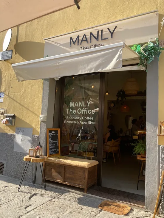 Outside Manly is a bench in the doorway and a small chalkboard menu.