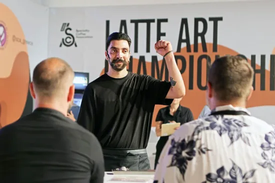 A barista raises a fist at the Latte Art Championship.