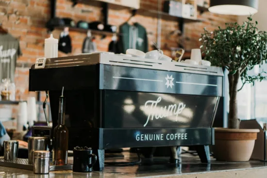 An espresso machine with a Thump Coffee logo on it on a counter.