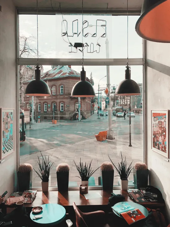 A view of the street from inside the window of Elska, with pendant lights hanging over the tables.