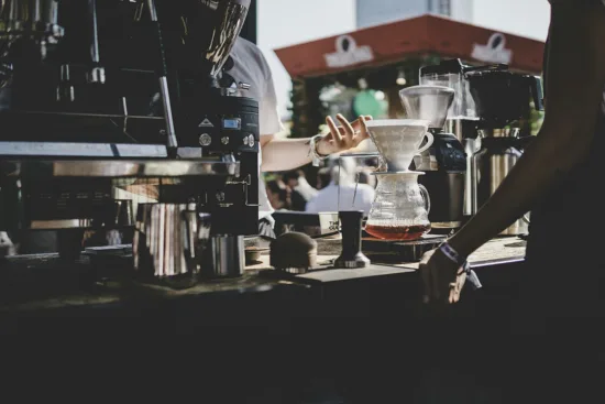 A customer interacts with a barista making a pourover.