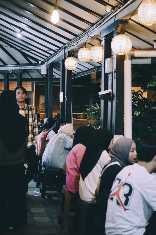 People sit inside a crowded shop.