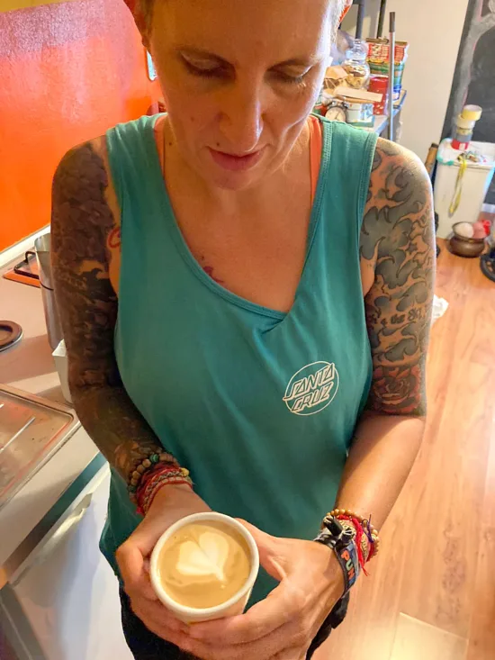 The author holding a latte with latte art.