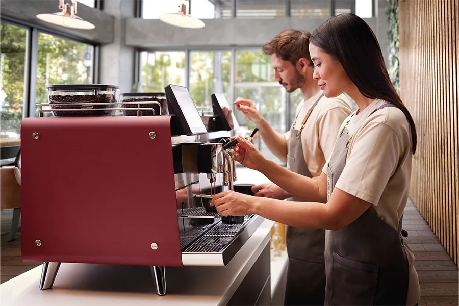 Two baristas use two Mytico Due machines to make beverages.