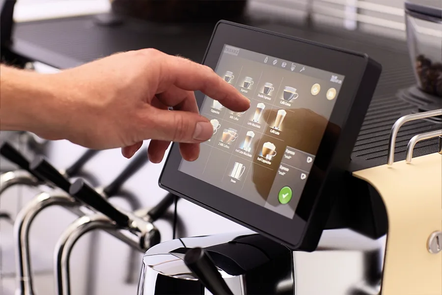 A finger is touching the touchscreen controls of the Mytico Due.