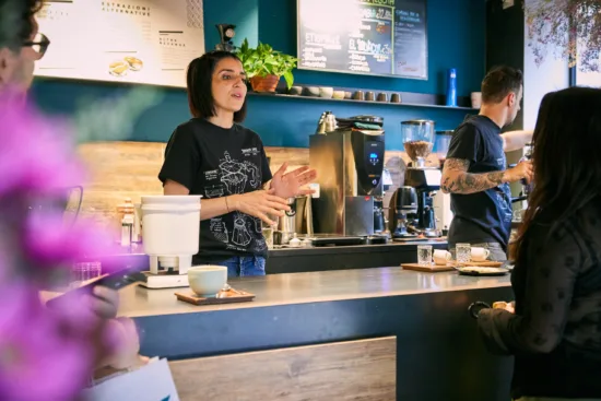 Elisa talks to customers behind the bar while Fabio works the espresso machine.