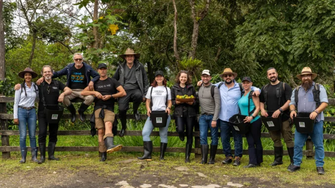 A group of people stand in front of a fence on a farm.