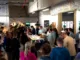 Large group gathered around a tasting table.