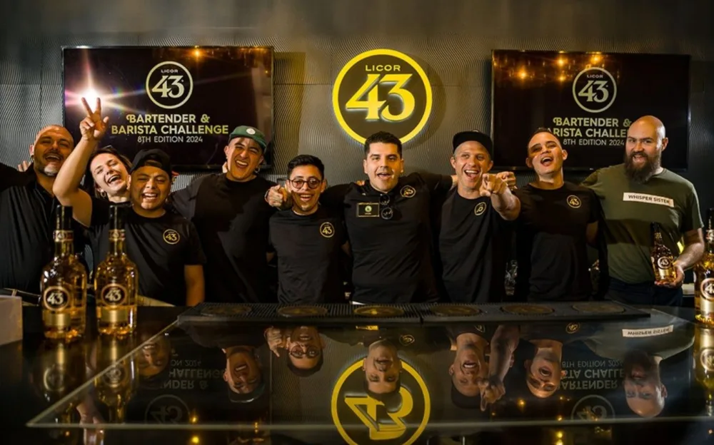 Competitors form the Licor 43 Bartender & Barista Challenge use by a table.