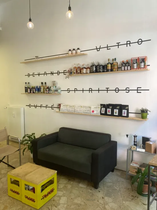 Shelves of spirit bottles and plants above a couch inside Ammazza.