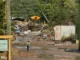 Devastated buildings and shrapnel in NC. A person walks through the mud.