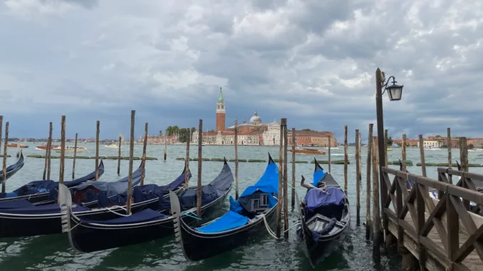 A row of small gondolas anchored in Venice.