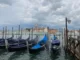 A row of small gondolas anchored in Venice.