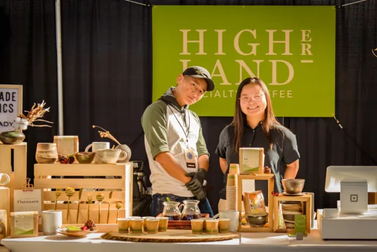 Two people at the Higher Land Specialty Coffee booth.