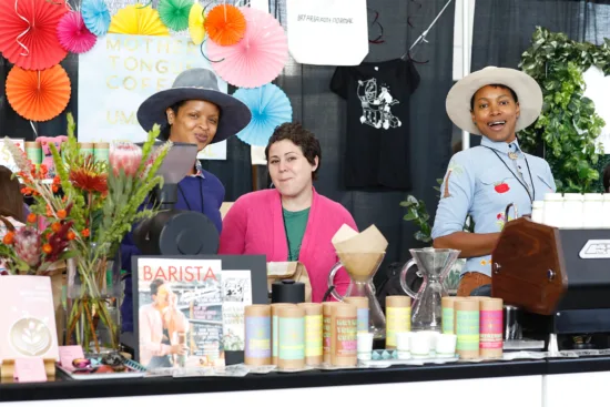 Three people behind a booth with espresso and pourovers. 