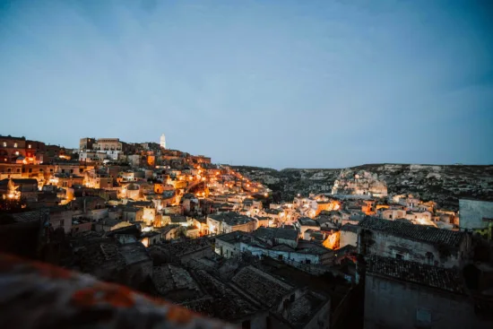 A city at dusk with neighborhoods lit up with yellow street lights.