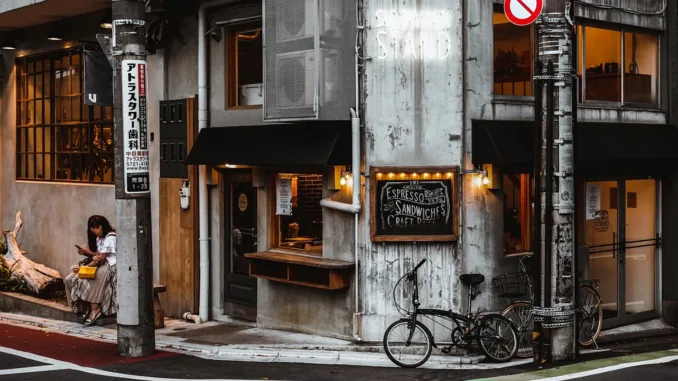 A street corner with a cafe, bicycle, and signage.