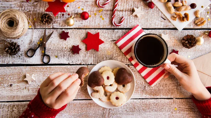 Holiday wrapping and cookies with a coffee cup.