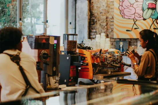 Baristas work behind an espresso bar.